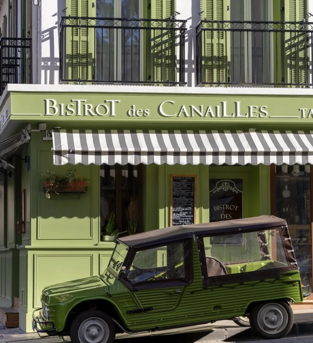 Façade du 133 rue d'Orves : balcons aux volets verts, ardoise du jour et Citroën Méhari verte garée devant